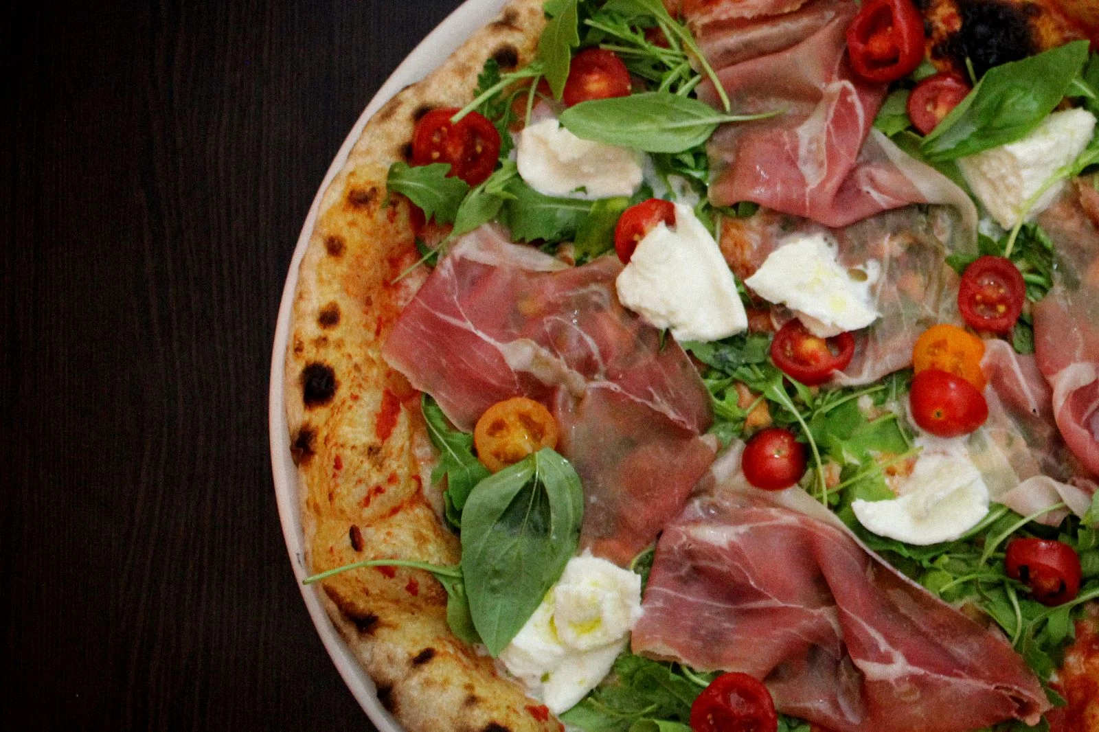 Pizza mit Prosciutto, Rucola und Mozzarella bei Preferita